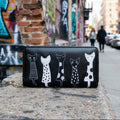 Cartera negra Y2K con detalles dorados y adorno de gatos